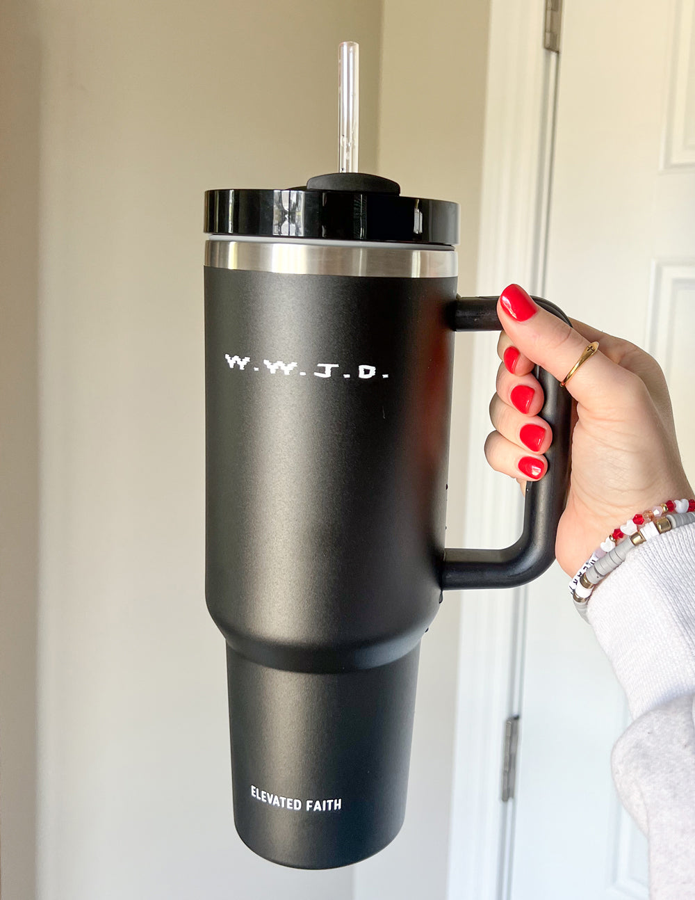 Black insulated tumbler with lid and straw, side handle, WWJD logo and "Elevated Faith".