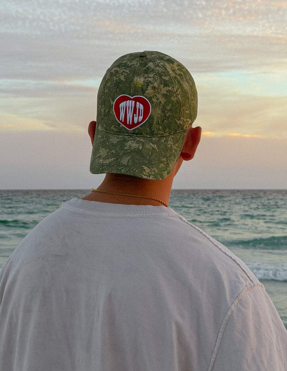 WWJD camo baseball cap with red heart front logo, shown from the back