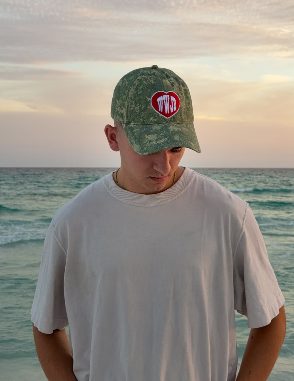 WWJD camo baseball cap with red heart logo patch, front view
