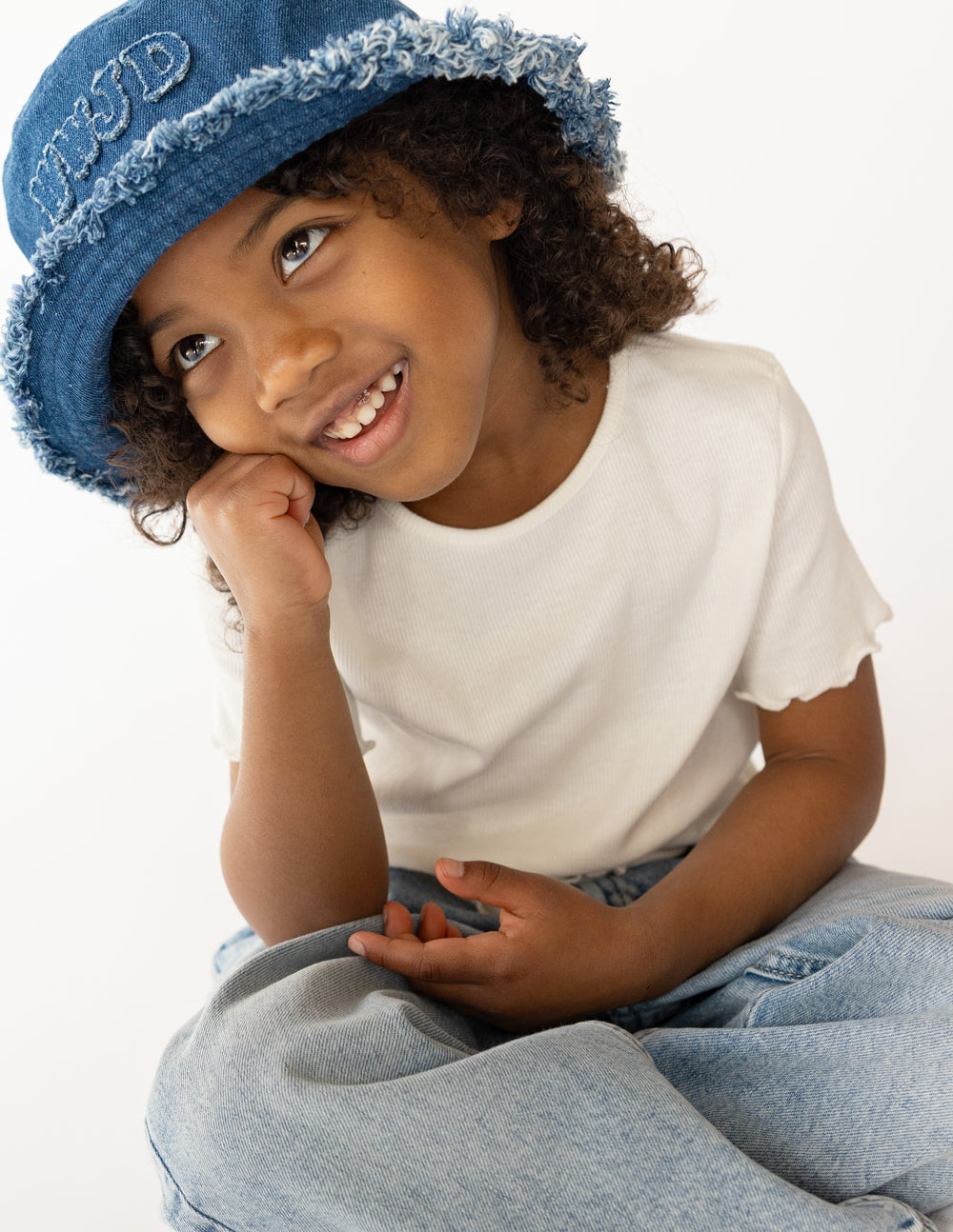 Denim bucket hat on child with embroidered WWJD patch and frayed edge, blue