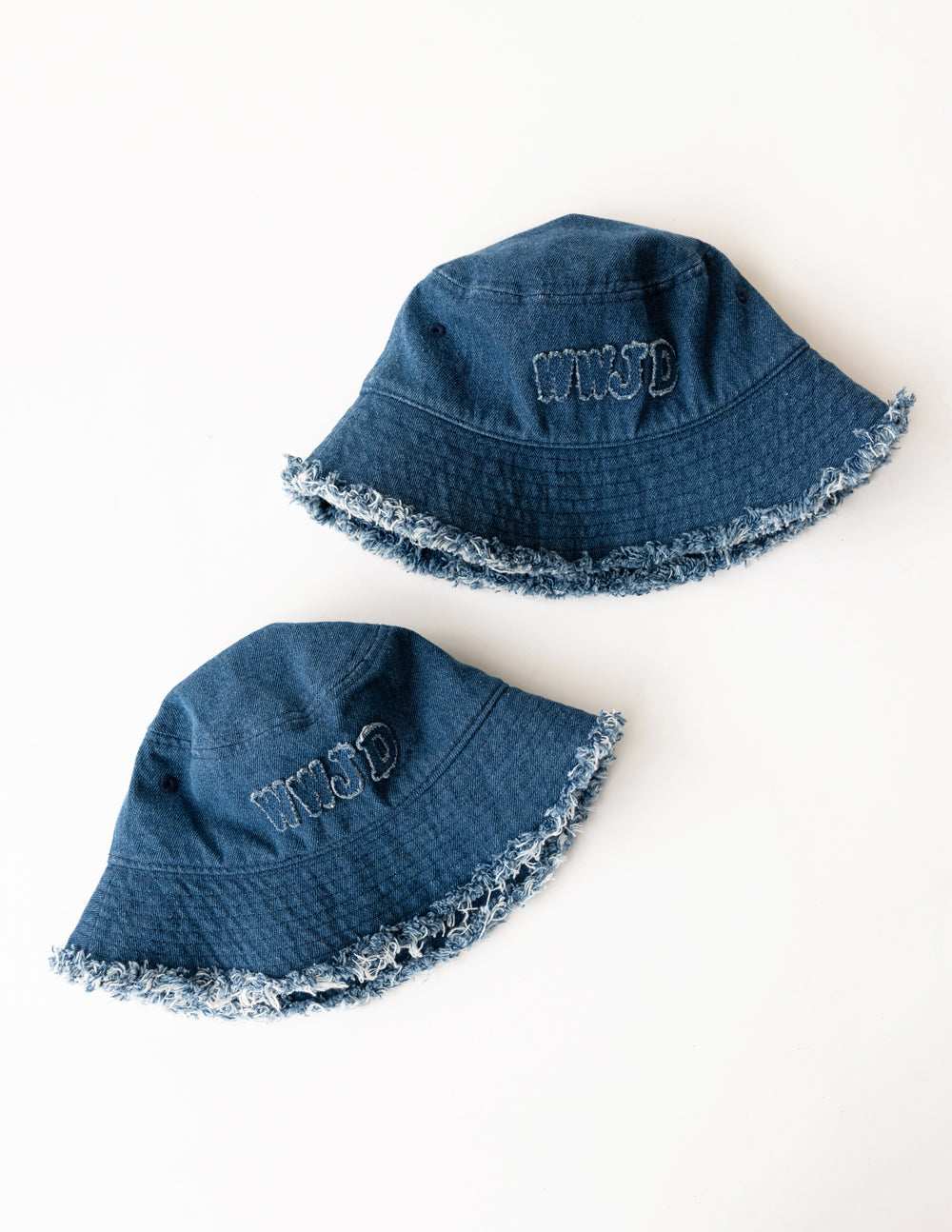 Two denim bucket hats with embroidered WWJD logos and frayed edges, blue