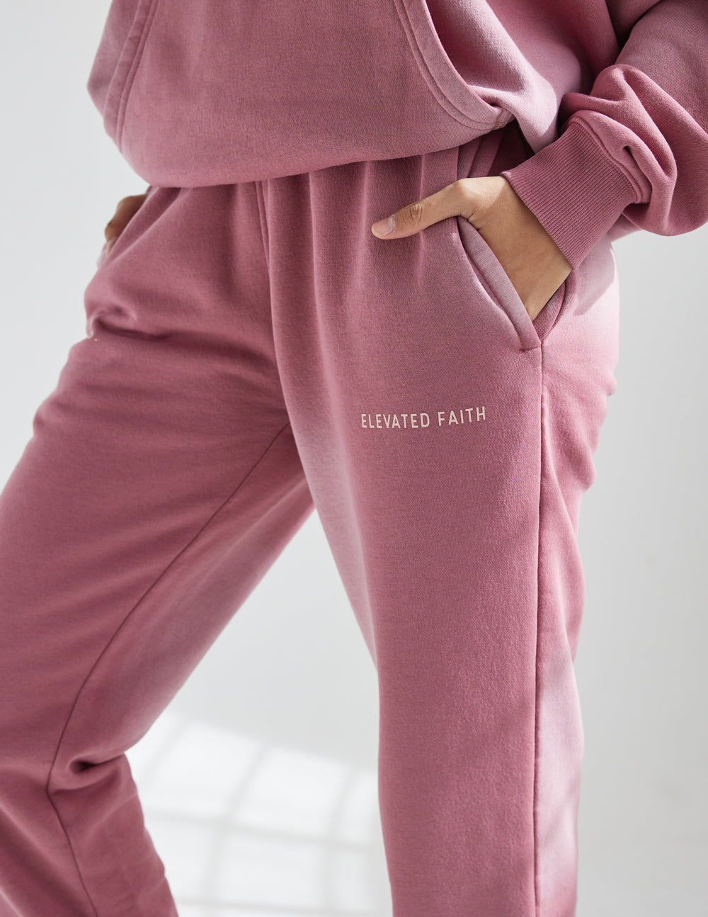 Pink sweatpants with drawstring and 'Elevated Faith' logo