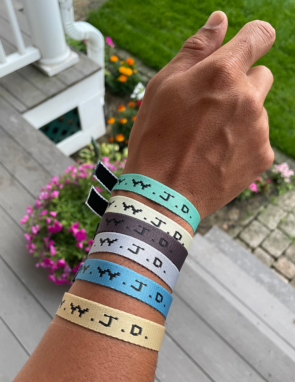 Fabric surf bracelets with WWJD print on wrist, adjustable clasp ends visible