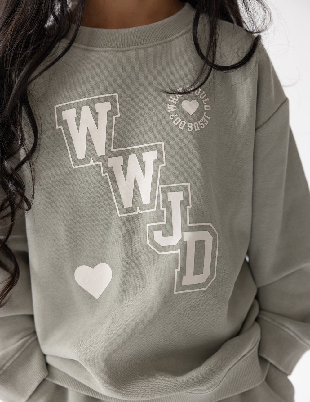 Kids varsity crewneck sweatshirt close-up in light gray with WJD front graphic and heart