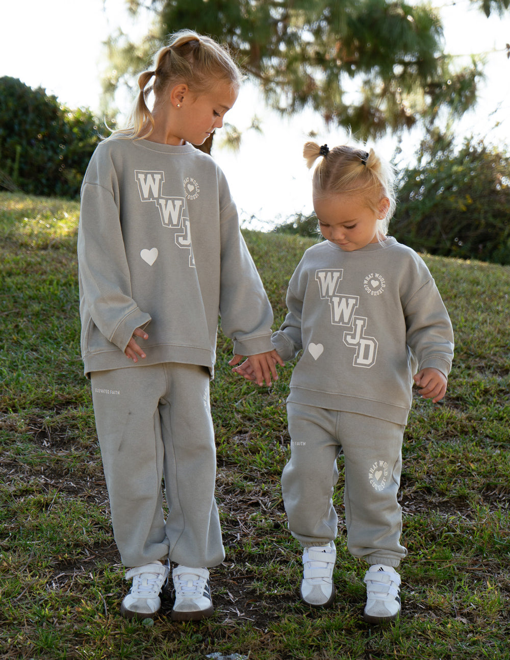 Kids varsity crewneck sweatshirt in light gray with WJD graphic worn by child