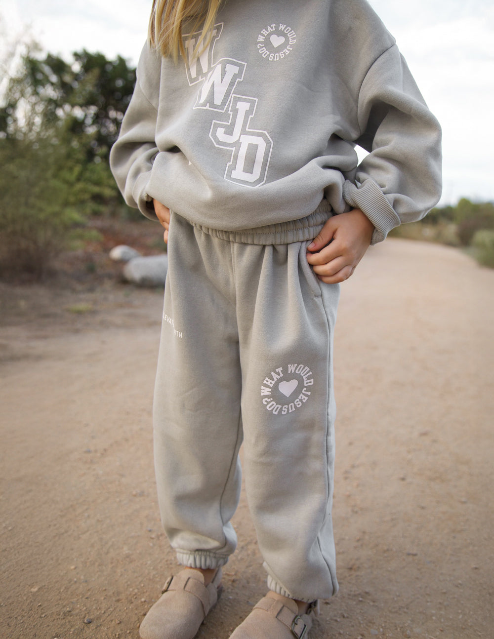 Light gray kids sweatpants with elastic cuffs and waistband, printed heart logo