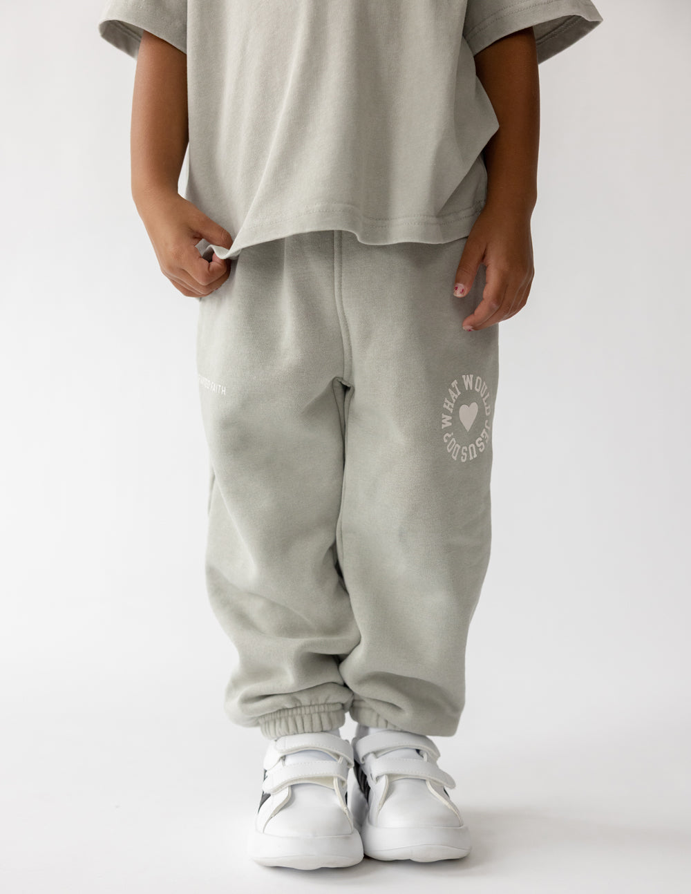 Light gray kids sweatpants with side heart logo and elastic cuffs, full view