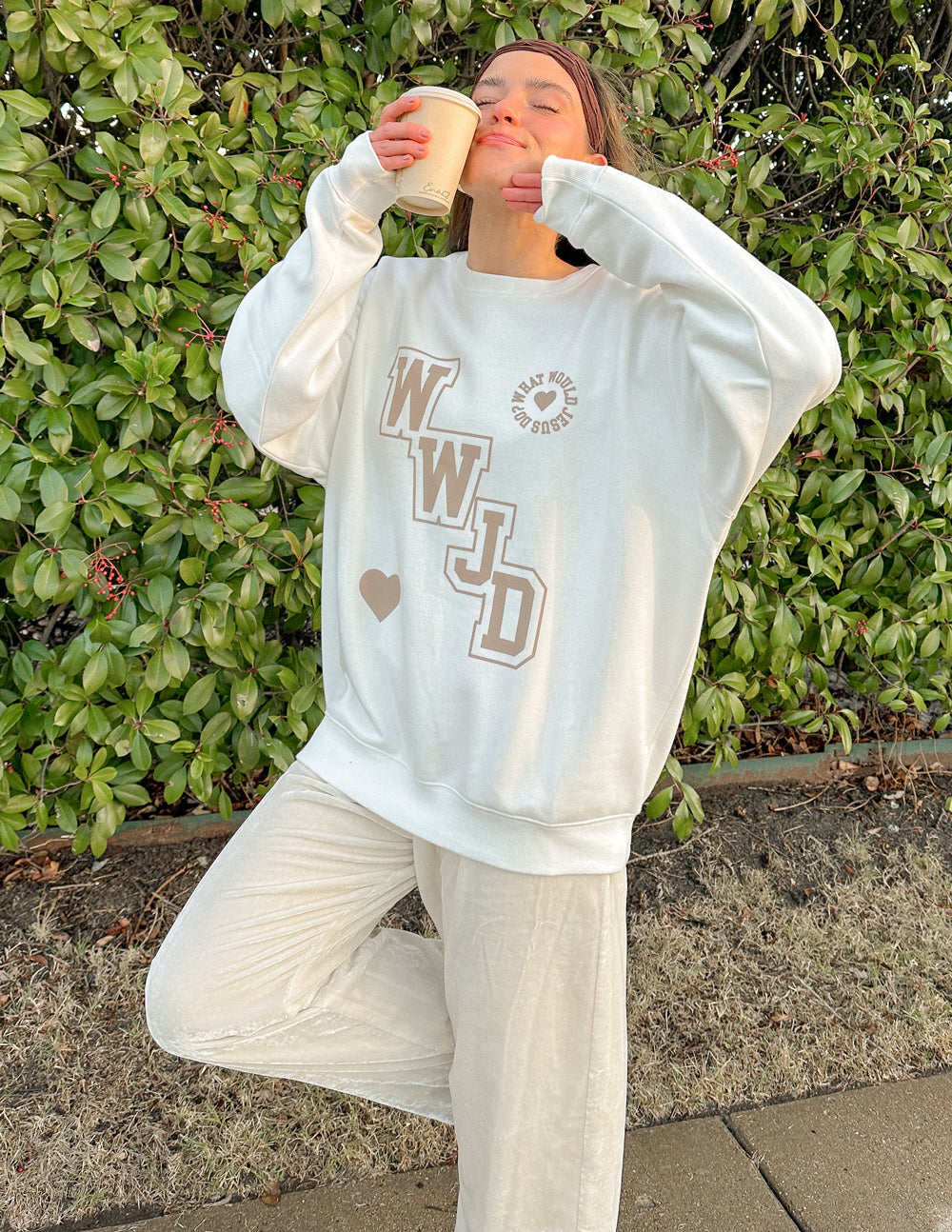 Off-white unisex crewneck sweatshirt with WWJD varsity print and heart accents
