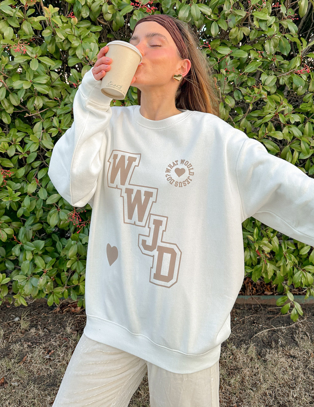 Off-white unisex crewneck sweatshirt with WWJD varsity logo and heart detail