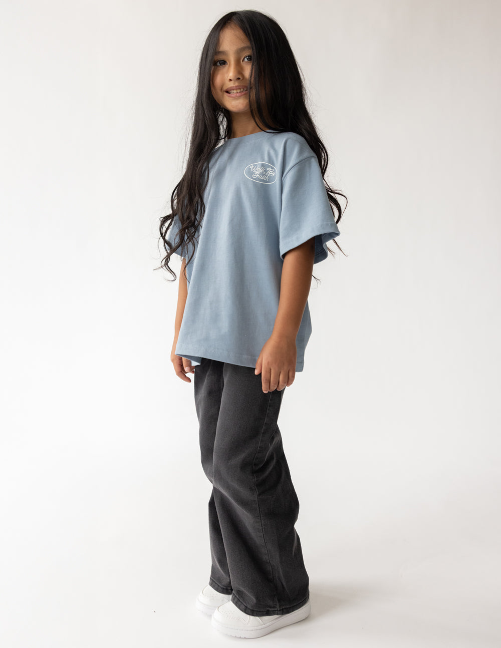 Light blue kids T-shirt with short sleeves and small front "Walk by Faith" logo