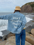 Light-wash denim jacket with large back graphic text and button front