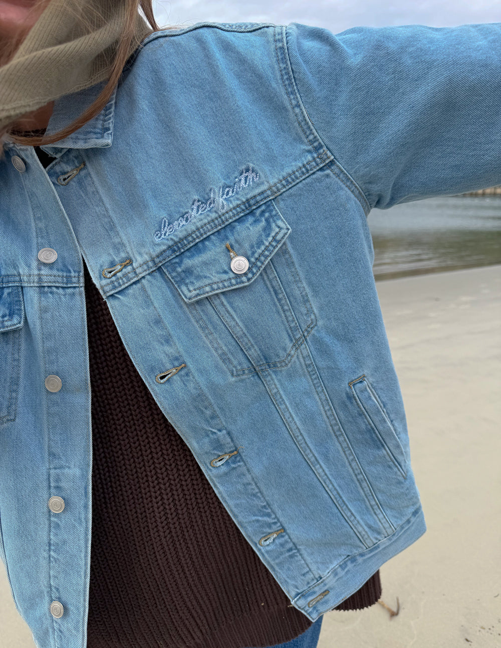 Light-wash denim jacket detail: chest flap pocket with button
