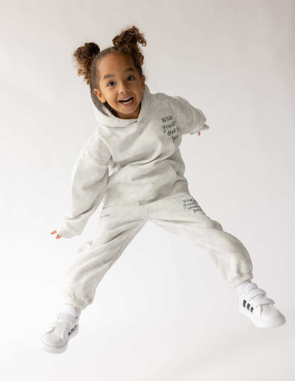 Kids pullover hoodie in light gray with hood and front graphic text “What A Friend We Have In Jesus”.