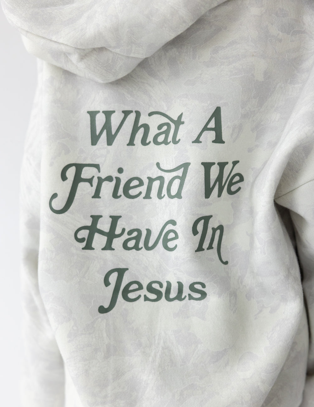 Kids hoodie in light gray, close-up of back graphic text “What A Friend We Have In Jesus”.