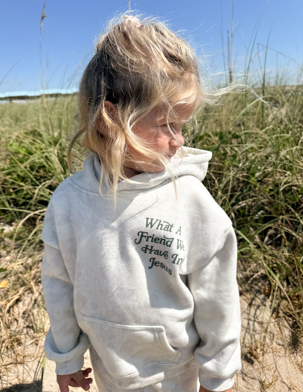 Kids pullover hoodie in light gray with hood and front graphic “What A Friend We Have In Jesus”.