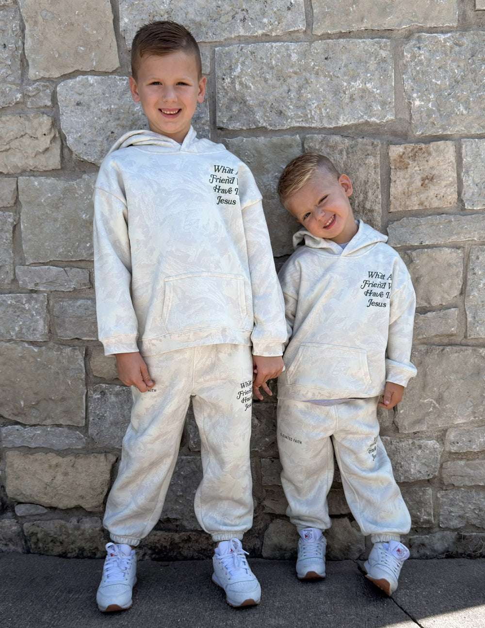 Kids sweatpants with logo text print and elastic cuffs, worn with sneakers