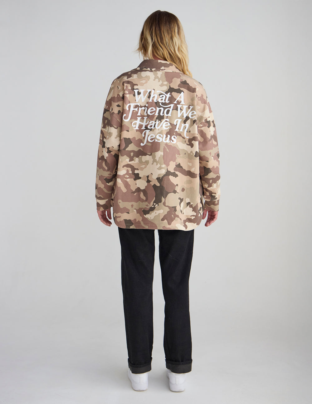 Camouflage shacket jacket with “What a Friend...” text on back.