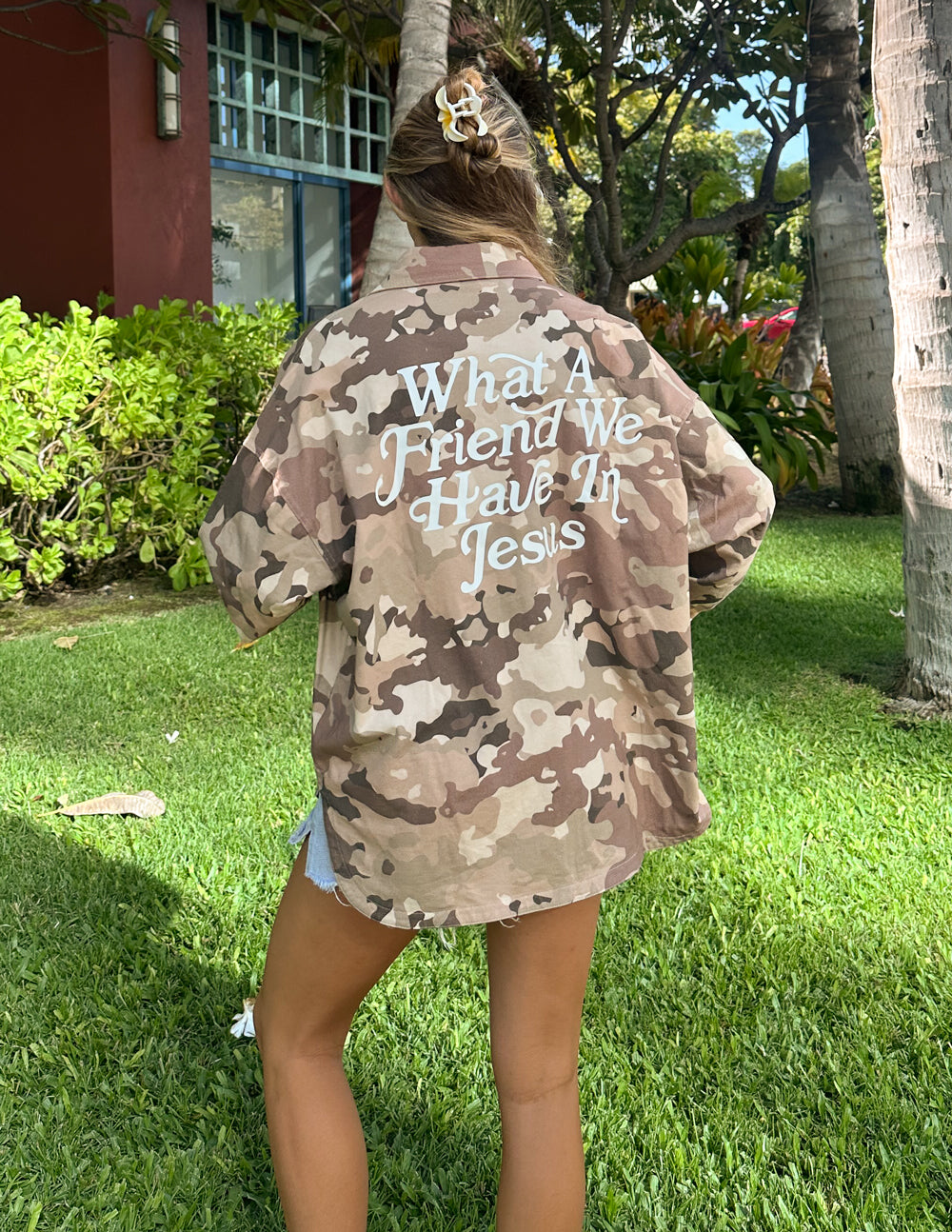 Camouflage shacket jacket back with large “What a Friend...” wording.