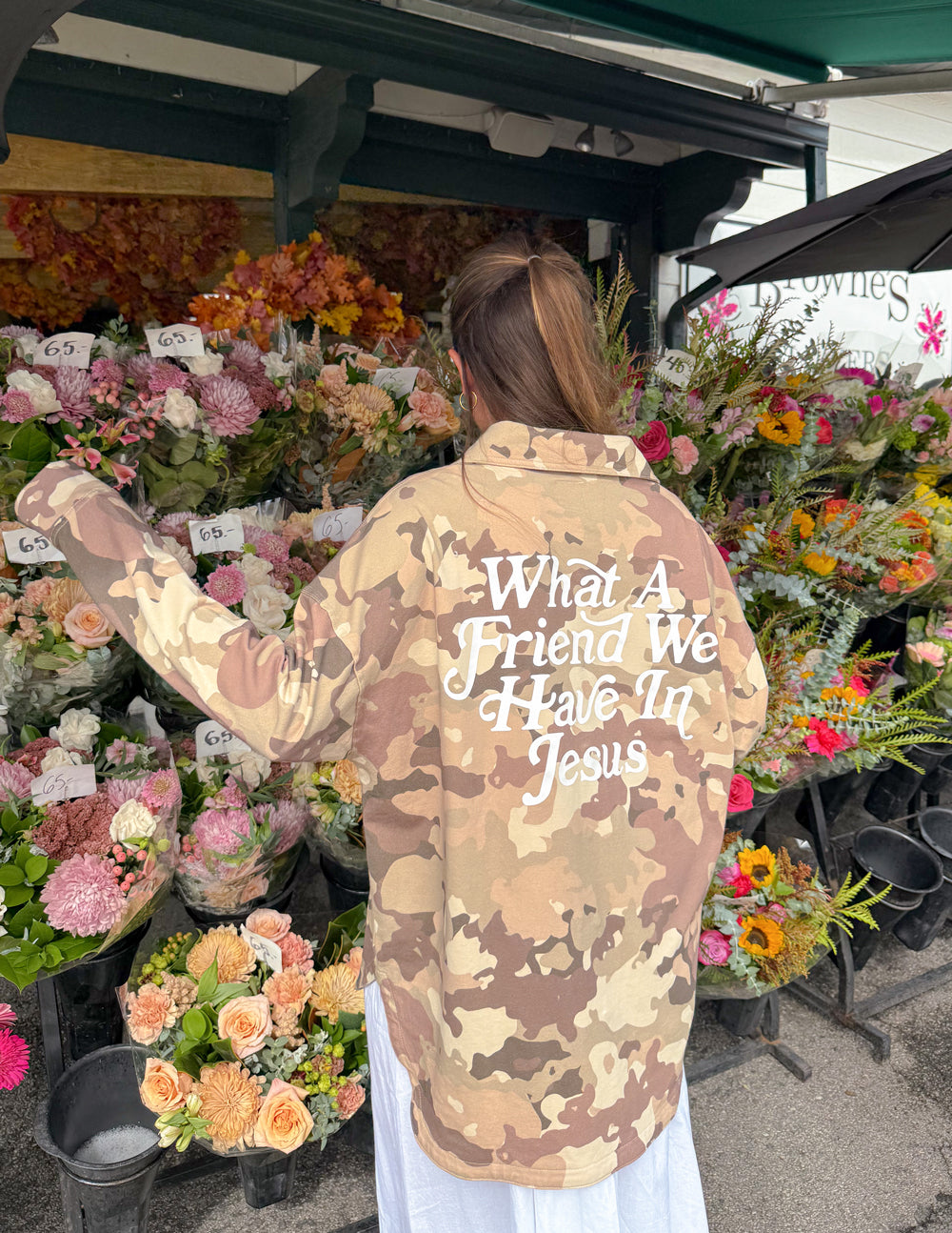 Camouflage shacket jacket back with “What a Friend...” wording.