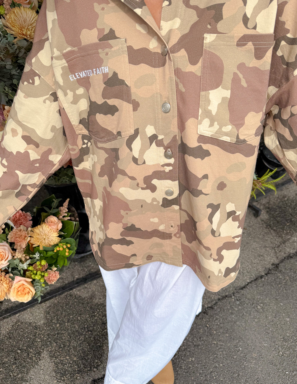Camouflage shacket jacket close-up with chest pocket and “Elevated Faith” text.