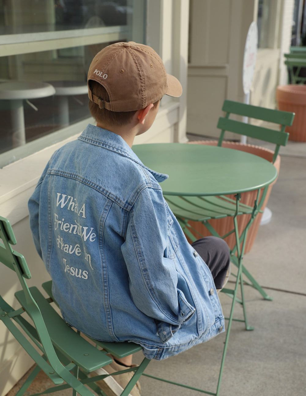 Kids light-wash denim jacket with back inspirational text print, mentioning Jesus