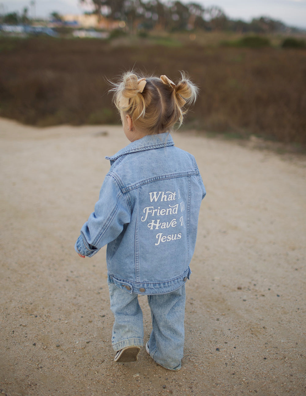 Kids light-wash denim jacket with back inspirational text print mentioning Jesus