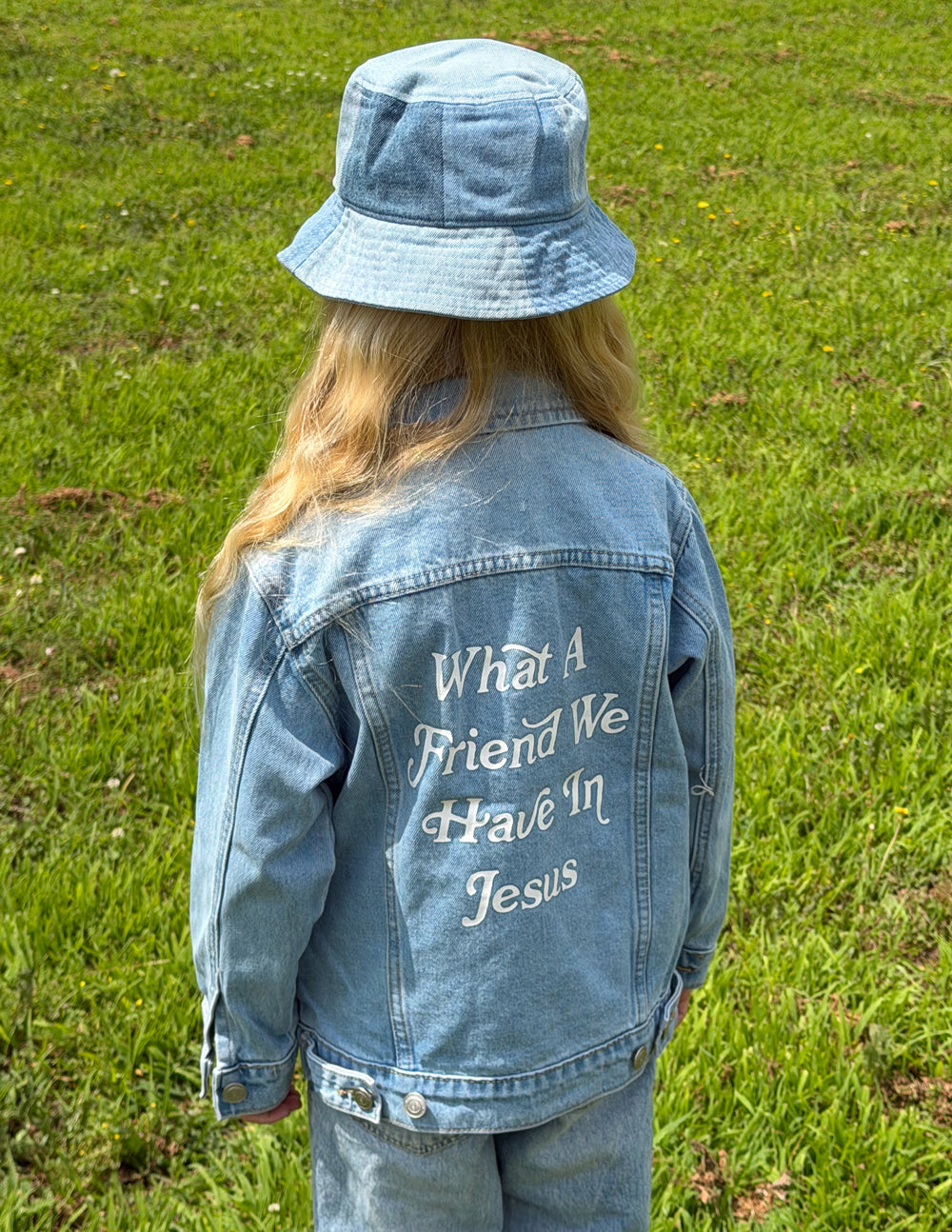 Kids light-wash denim jacket with back inspirational text print mentioning Jesus