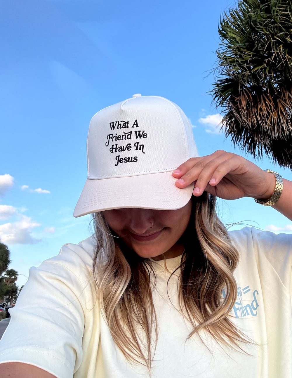 White bucket-style cap with embroidered “What a Friend We Have In Jesus” text