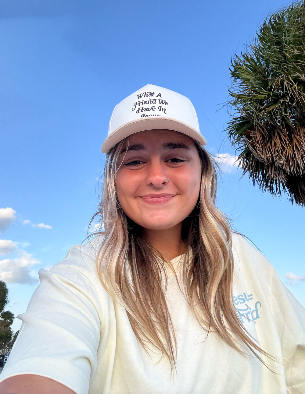 White cap on a model with “What a Friend We Have In Jesus” embroidered front