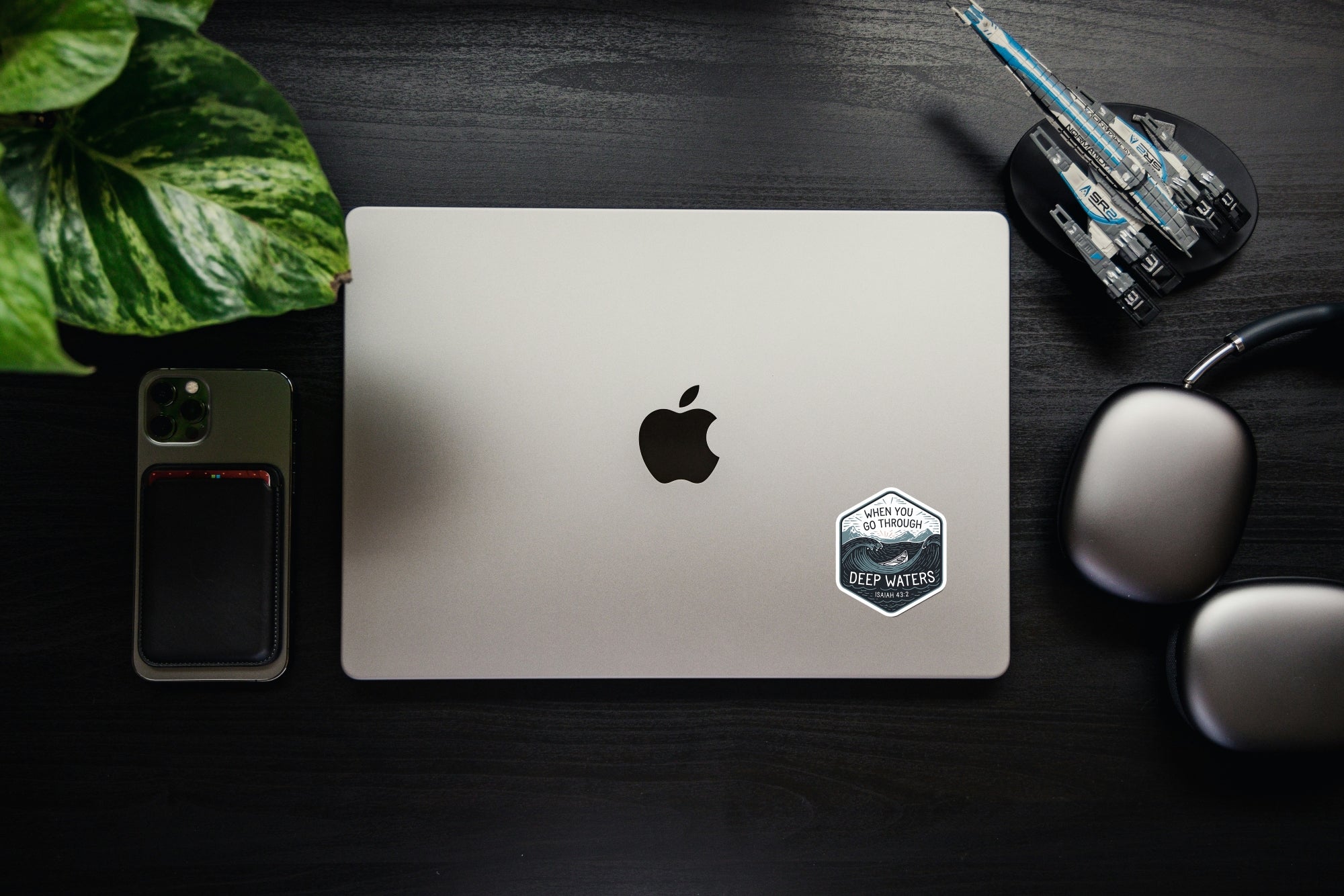 Laptop with small hex Christian sticker showing ocean waves and Isaiah 43:2.