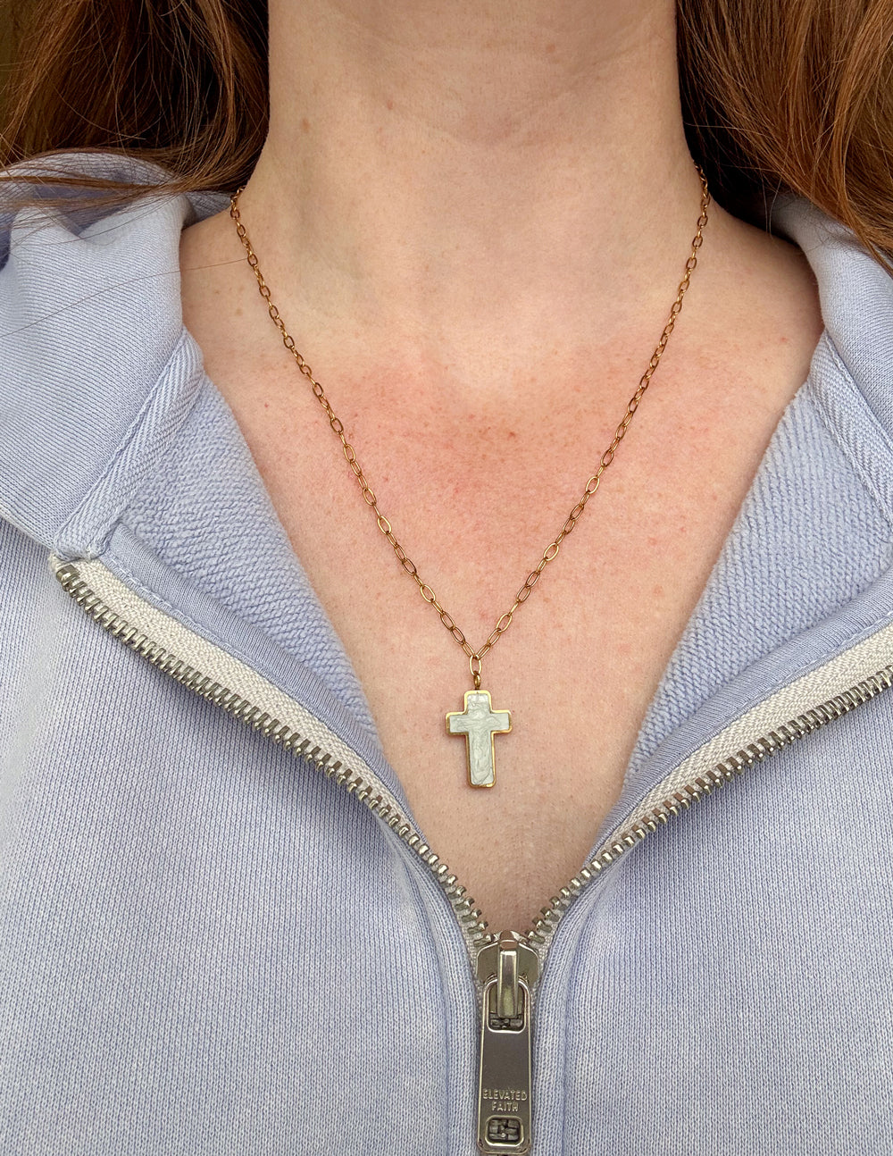 Gold cross necklace with white enamel cross pendant plus small charm detail