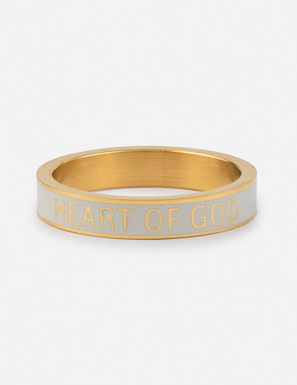 White enamel ring with gold band and embossed text reading HEART OF GOD