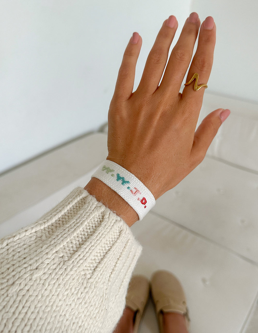 White woven bracelet with green and red embroidery on wrist