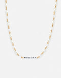 Letter necklace with gold-tone beads, white pearls, and 'WORTHY' bar pendant