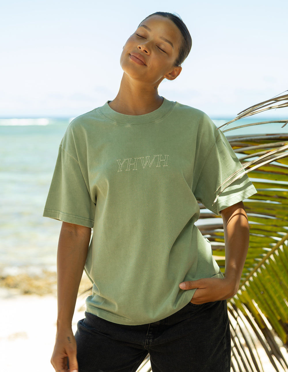 Unisex sage green T-shirt with small YHWH logo at front.