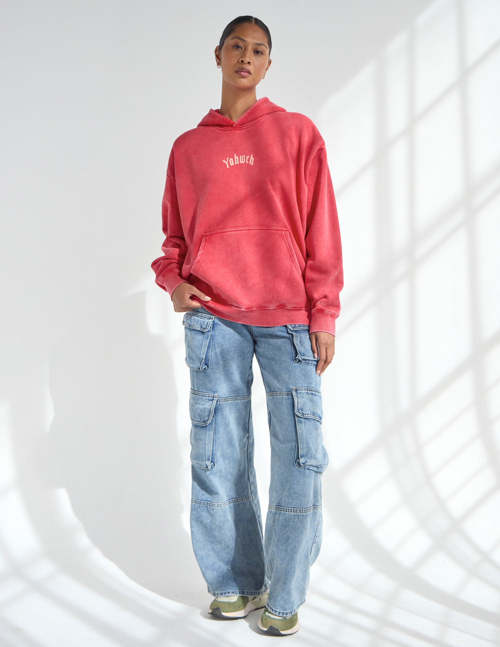 Red unisex hoodie with hood and small chest logo, relaxed fit.
