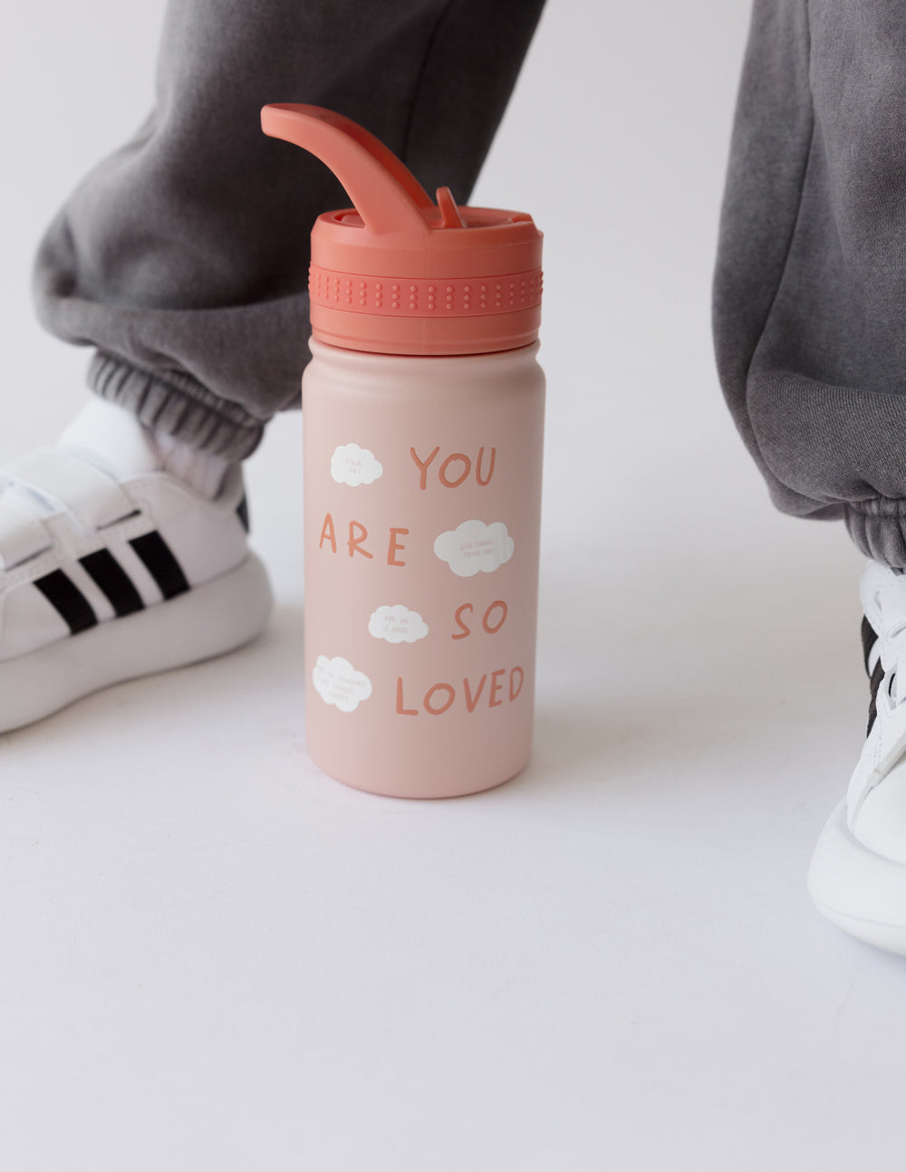 Pink kids water bottle with orange flip-top lid and cloud "You are so loved" text.