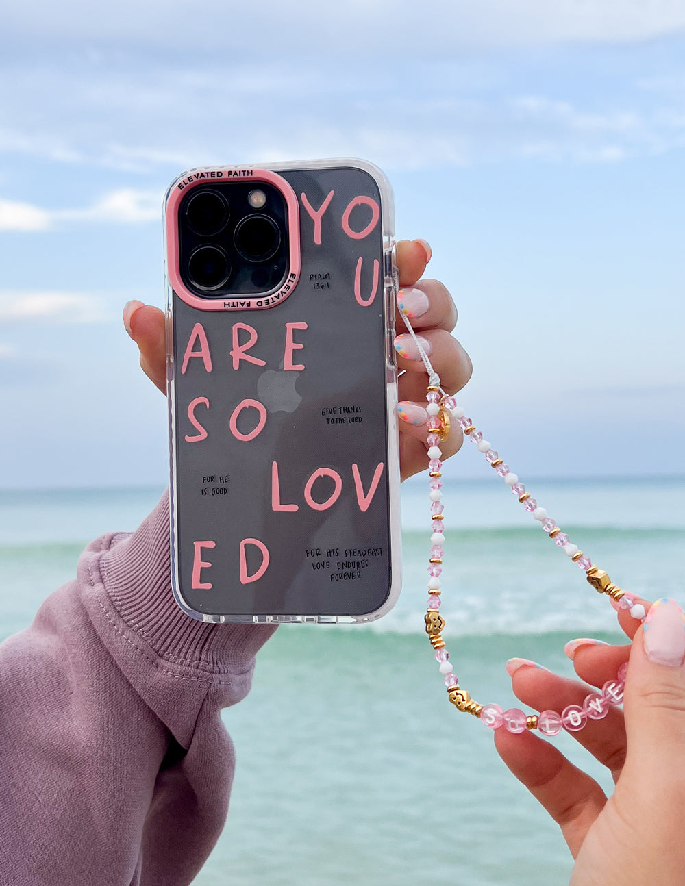 Pink and gold beaded phone charm with gold connectors, hanging from phone case