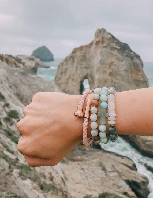 Amazonite cross bracelet on wrist, light blue bead strands with a cross charm