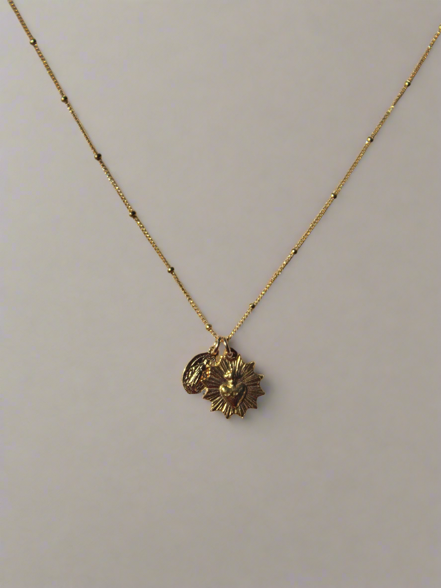 Gold-tone pendant necklace with sacred heart medal charm on thin chain