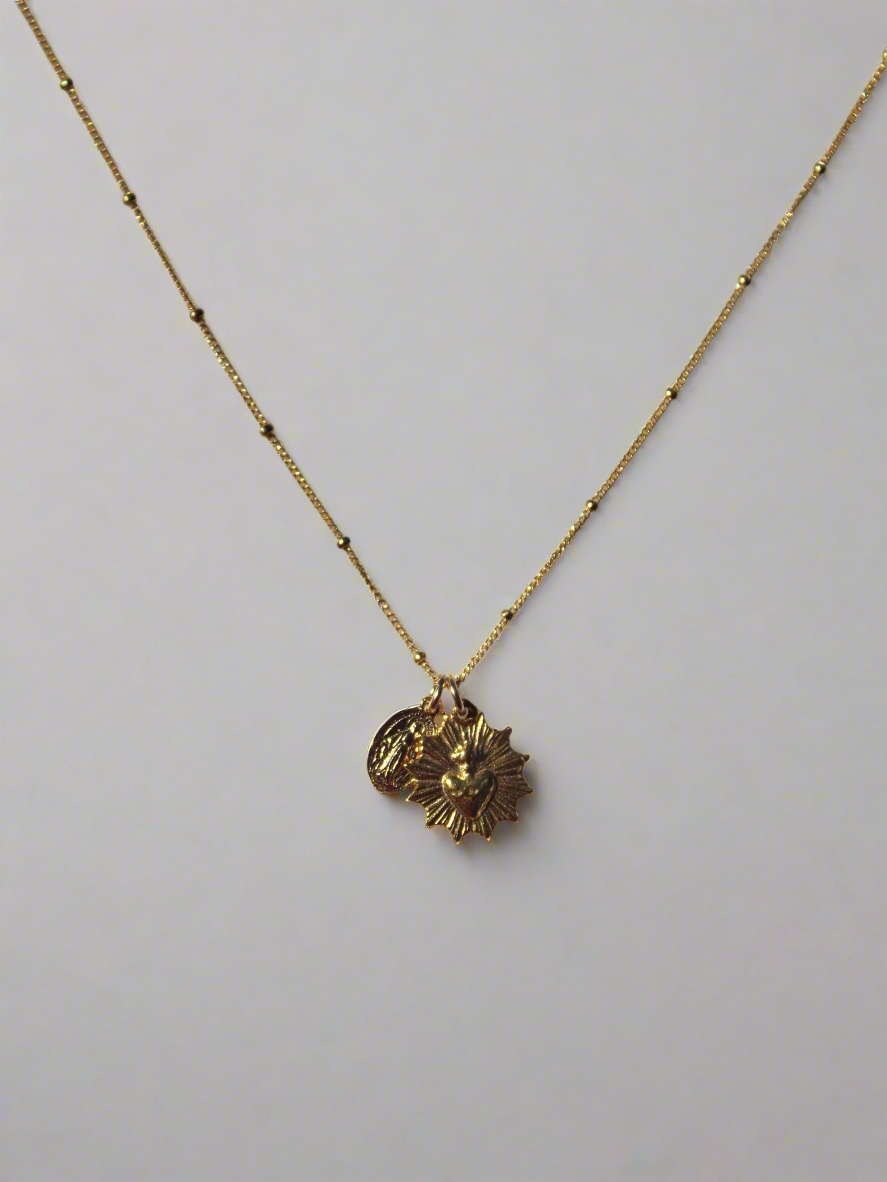 Gold-tone heart and medal pendant necklace with single large charm on chain