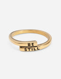 Wide gold ring with "BE STILL" engraving