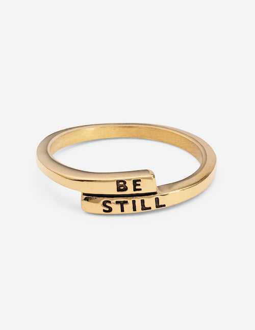 Wide gold ring with "BE STILL" engraving
