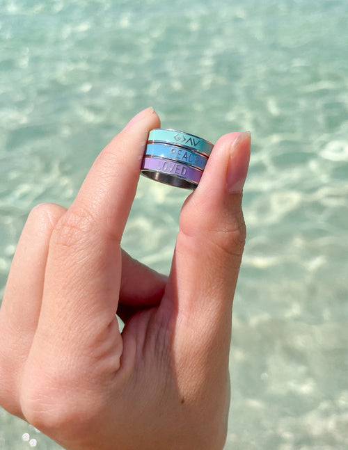 Peace enamel ring on a hand, blue band with PEACE lettering