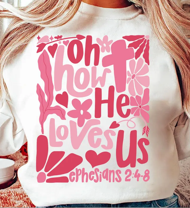 White sweatshirt with large pink 'Oh How He Loves Us' graphic