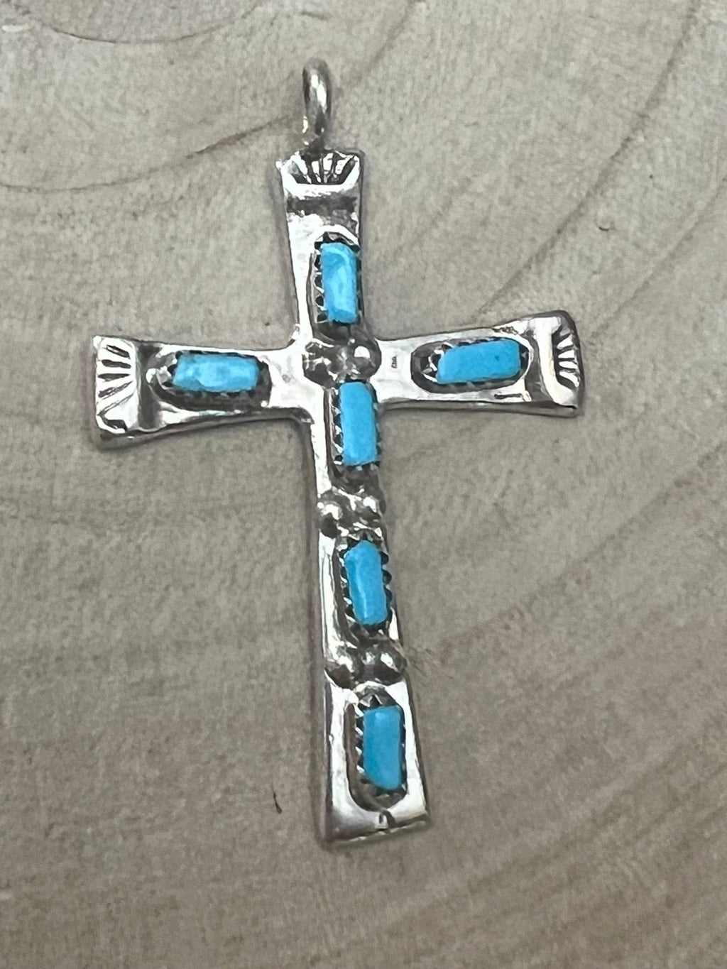 Turquoise inlay cross pendant with silver-tone bezel and four blue stones.