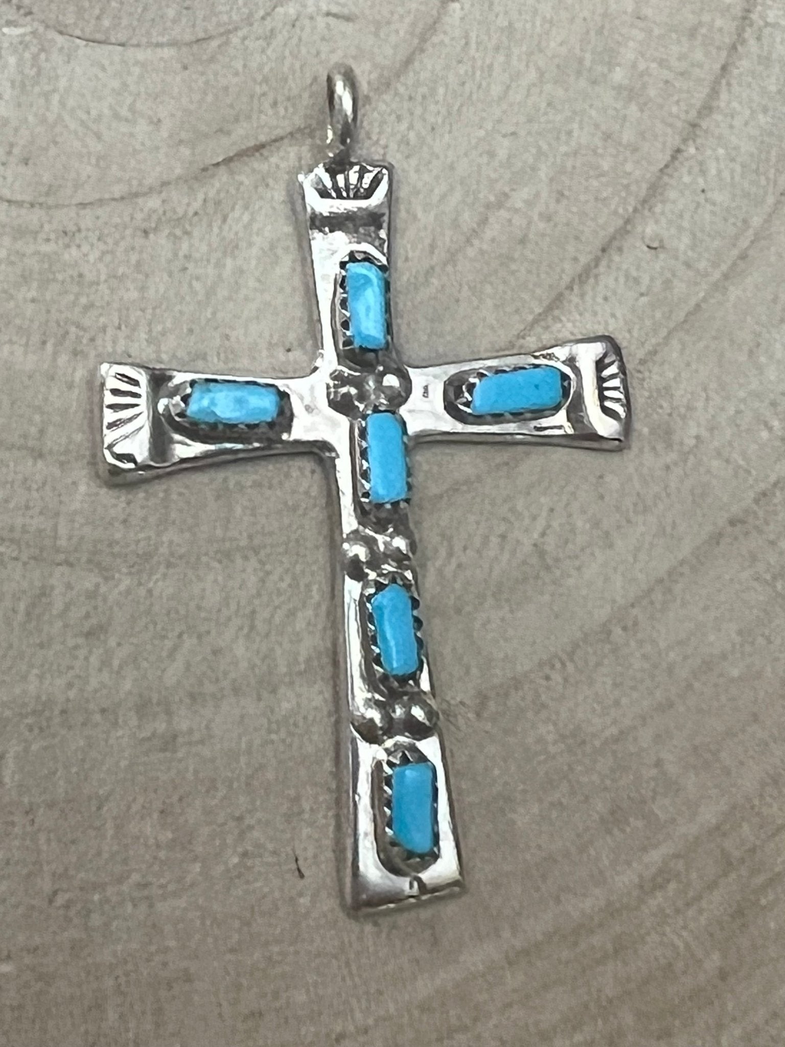 Turquoise inlay cross pendant with silver-tone bezel and four blue stones.