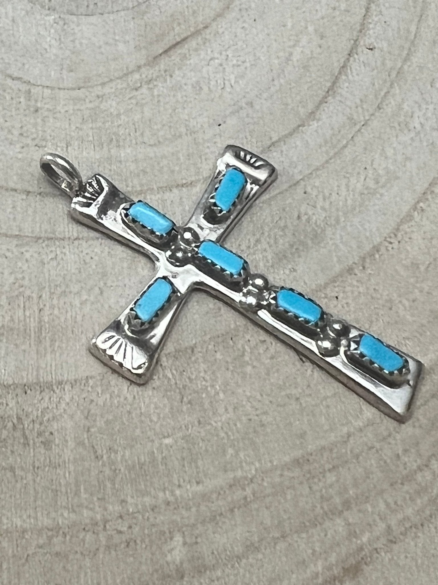 Turquoise cross pendant with silver-tone frame and blue rectangular stones on arms.