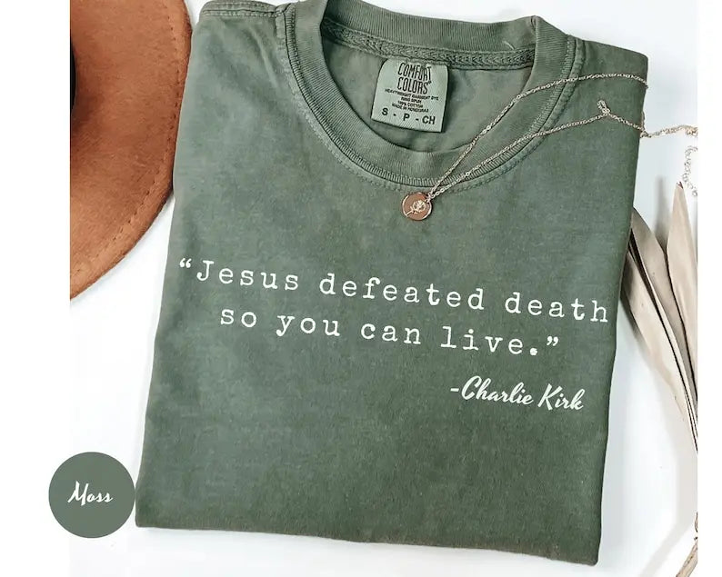 Dark green crewneck T-shirt with 'Jesus defeated death' graphic and small pendant