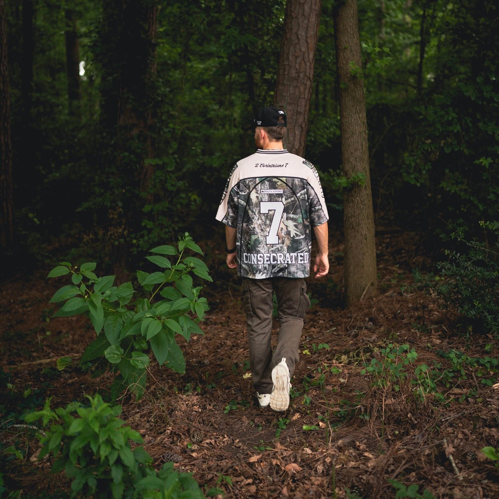 Oversized jersey back view with woodland camo pattern and number 7, worn outdoors